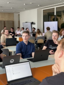 Students discuss and work on laptops in a bright classroom during a generative AI education workshop. The session supports hands on learning about AI tools and Gen AI skills.